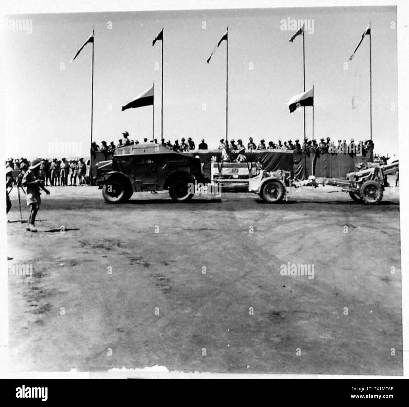 THE POLISH ARMY IN THE MIDDLE EAST, 1942-1943 - Ordnance QF 25 pounder gun towed by a Morris Commercial C8 Field Artillery Tractor (Quad) passing by a stage where General Władysław Sikorski, the Commander-in-Chief of the Polish Armed Forces, is watching a parade of one of the units of the 5th Wilno Infantry Division, at their camp around Kirkuk. Photograph taken during General Władysław Sikorski's official tour in Iraq, Polish Army, Polish Armed Forces in the West, Polish Corps, II, Polish Armed Forces in the West, Polish Army in the Soviet Union, 5th 'Wilno' Infantry Division, Sikorski, Włady Stock Photo