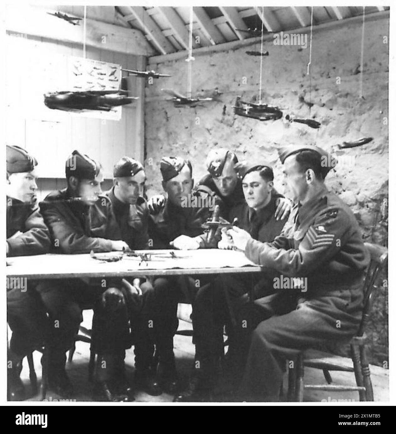 MARITIME ARTILLERY UNIT IN TRAINING - An aircraft recognition class grouped round a table name some of the model planes, British Army Stock Photo