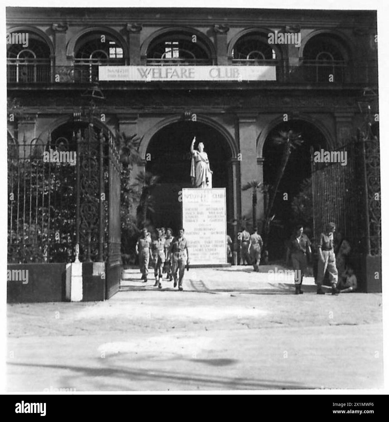 ITALY : 'PTE.SMITH' COMES TO TOWN - The front entrance of the NAAFI, with the large iron gates open, British Army Stock Photo