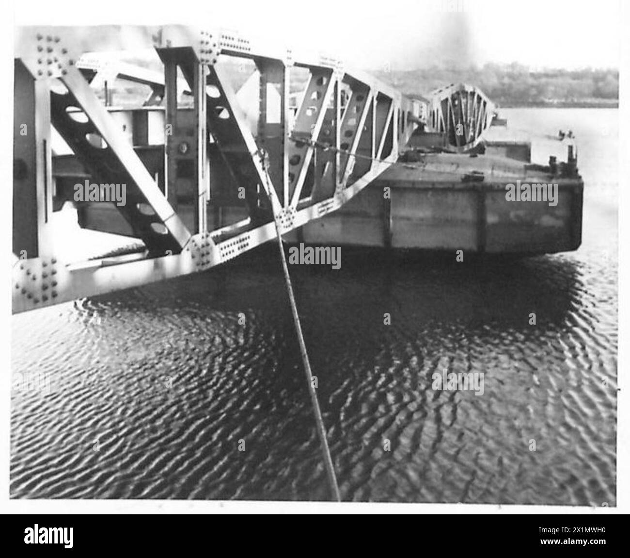 Wire struts are connected between a bridge and barges as part of a ...