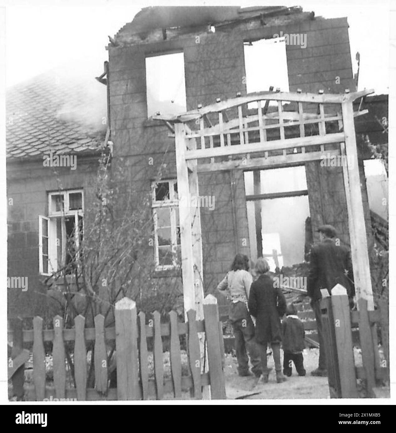 ADVANCE OF THE 5TH GUARDS ARMOURED BRIGADE - German civilians watch their home burn, in the village of Freren, after it had been fired by the Gestapo, British Army, 21st Army Group Stock Photo