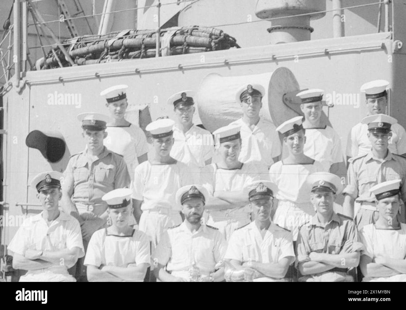 MEN OF THE HMS SUFFOLK, A CRUISER SERVING WITH ADMIRAL JAMES SOMERVILLE'S EASTERN FLEET. 12 DECEMBER 1943, TRINCOMALEE. THE MEN ARE DIVIDED INTO GROUPS BY TOWN AND/OR DISTRICT. - Suffolk group. Front row, left to right: Boy H Watts, Ipswich; Shpt C Randlesome, Lowestoft; AB D Bruce, Ipswich; Lieut Cdr Easey, RN, Lowestoft; Mr E Edwards, Gnr, RN, Leeston; Mne Bryant, Olton Bray; AB A Bray, Tudenham. Second row, left to right; Mne Cox, Ipswich; Sgt Phillips, RM, Woolpit; Boy B Watts, Felixstowe; AB S Collins, Felixstowe; O/Sea W Leggitt, Lowestoft. Third row, left to right: PO E Horsford, Ipswic Stock Photo