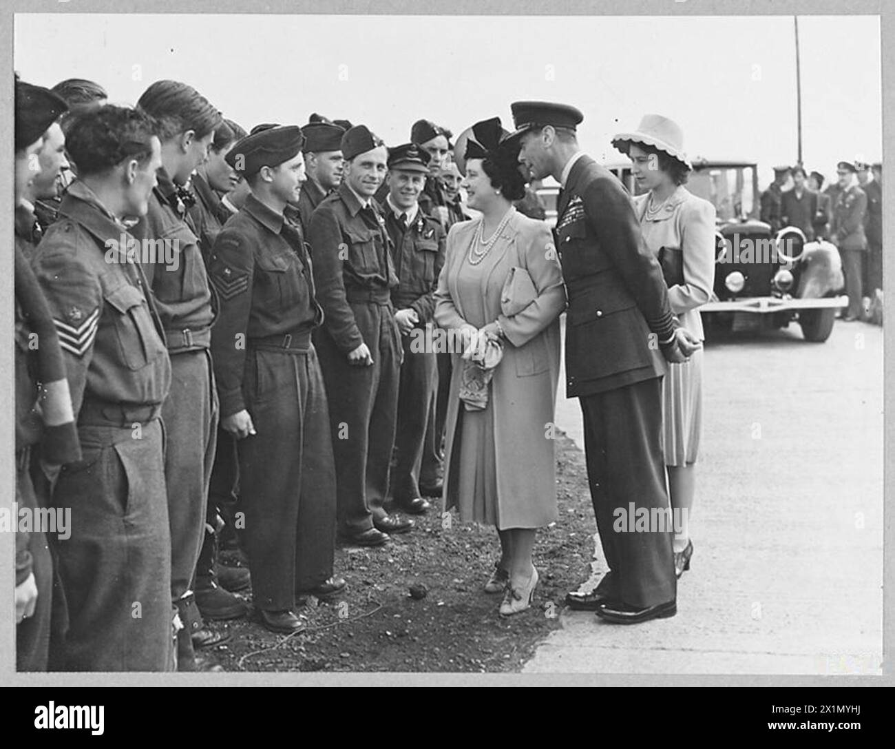 THE KING AND QUEEN, WITH PRINCESS ELIZABETH, VISIT BOMBER COMMAND AIRFIELDS. - The King and Queen accompanied by Princess Elizabeth have visited heavy bomber stations in Britain. Picture (issued 1944) shows - The King and Queen with Princess Elizabeth talking to R.A.F. Bomber Crews during their visit to R.A.F. Bomber Command airfields. They listened to accounts to attacks on targets in the Pas de Calais area from crews who had just returned from operations, Royal Air Force Stock Photo