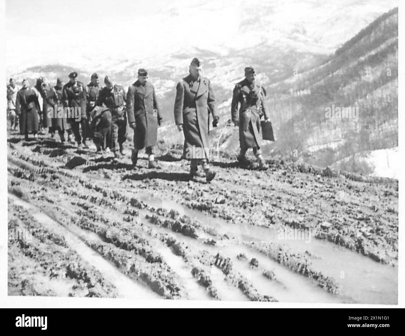 THE POLISH ARMY IN THE ITALIAN CAMPAIGN, 1943-1945 - General Kazimierz Sosnkowski, the C-in-C of the Polish Armed Forces, and his party walking alongside a muddy road outside San Pietro Avellana during his visit to various units of the 3rd Carpathian Rifles Division (2nd Polish Corps), 28/29 March 1944.General Stanisław Kopański, the Chief of the Polish General Staff, is walking behind General Sosnkowski followed by General Bolesław Duch, the Commander of the Division (holding a coat in his hands), Polish Army, Polish Armed Forces in the West, Polish Corps, II, Polish Armed Forces in the West, Stock Photo