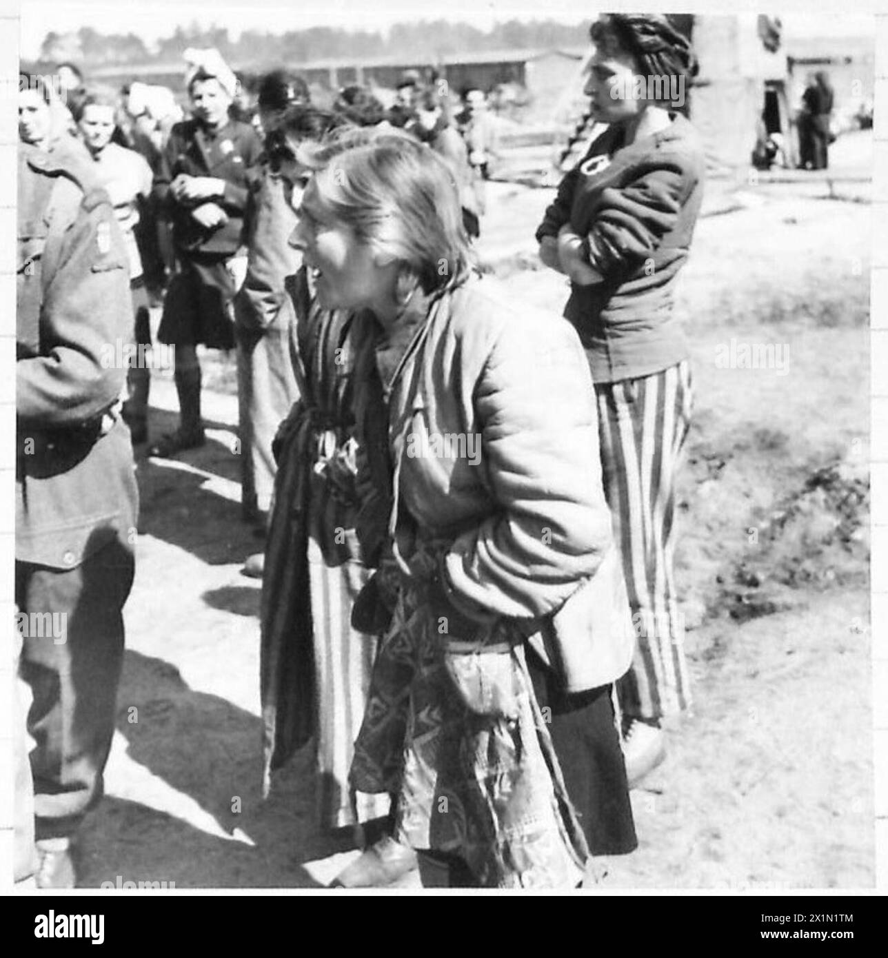 THE LIBERATION OF BERGEN-BELSEN CONCENTRATION CAMP, APRIL 1945 - Hela was born in a Jewish family in Tuszyn in central Poland which meant four years in concentration camps.She was in Łódź (Litzmannstadt) Ghetto, Auschwitz and Bergen-Belsen camps (in Belsen only for two weeks before British troops arrived). Hela Goldstein, a Polish inmate, and other female prisoners watching SS guards who dropped with exhaustion while loading lorries with bodies of dead inmates, 21 April 1945, Goldstein, Helena Stock Photo