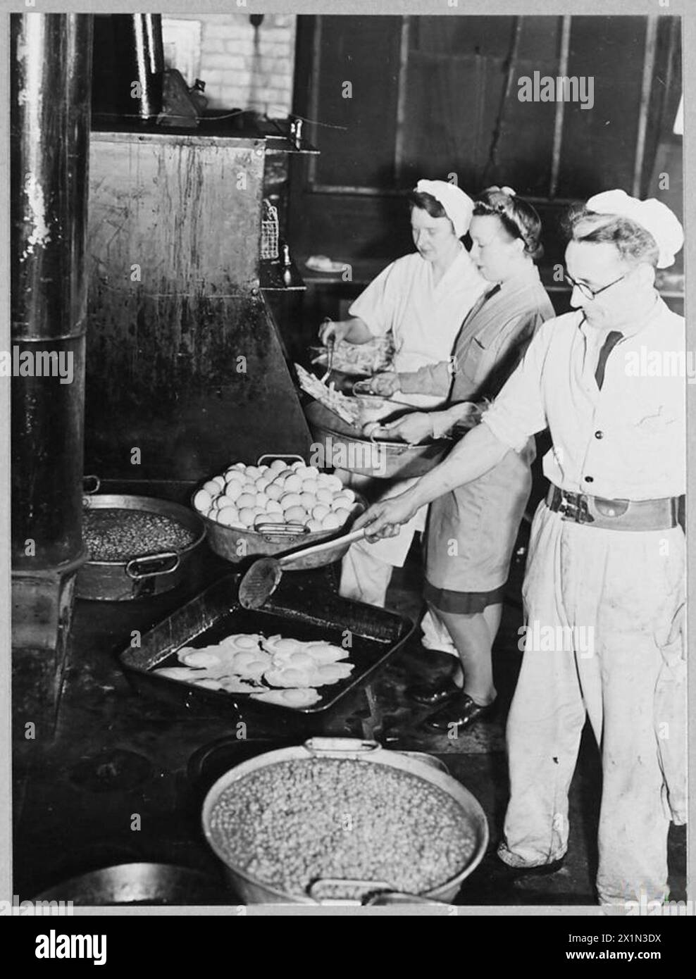Kitchen staff prepares breakfast of eggs, chips, and beans for aircrew ...