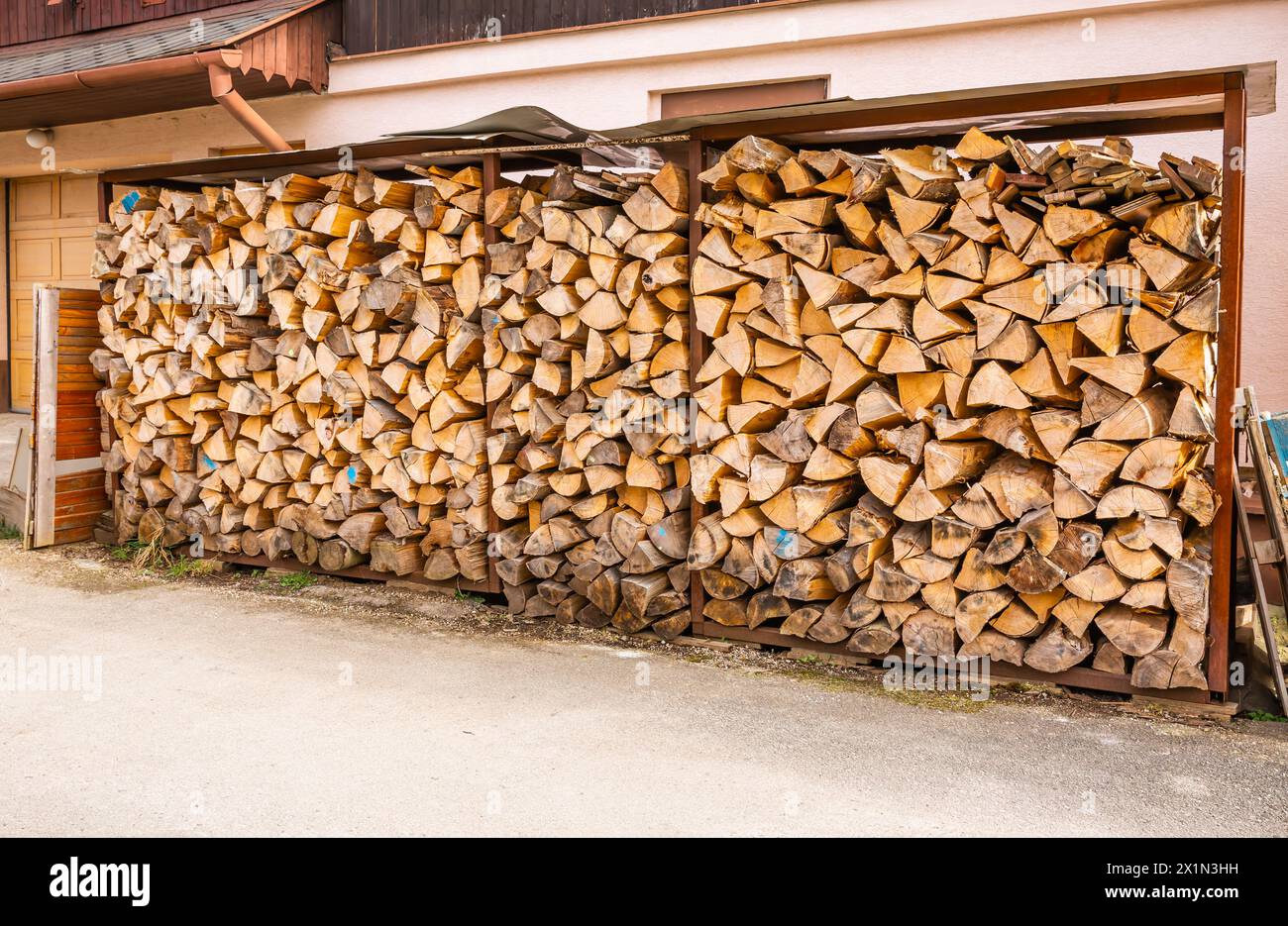 Stack of split firewood seasoning outside for sustainable energy for use in a wood stove Stock Photo