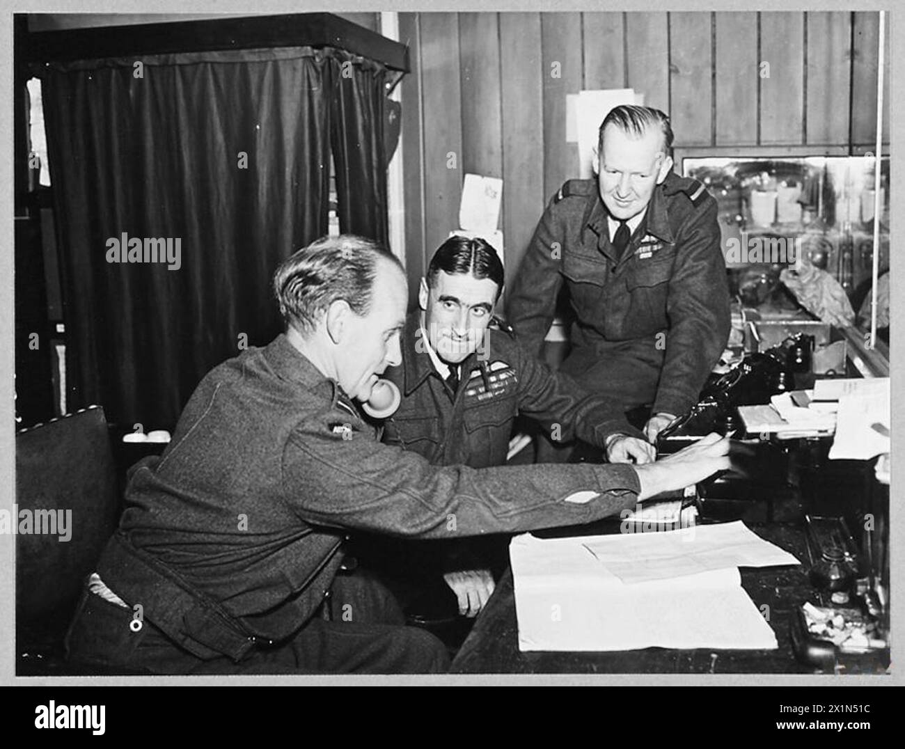 IN COASTAL COMMAND 'OPS' ROOM - Picture (issued 1944) shows - Air Vice Marshal B.E. Baker, CB.,DSO.,MC.,AFC., Air officer Commanding a Coastal Command Group [centre] with Air Commodore N.H. D'Aeth, CBE., [right] and Wing Commander J.C. Barclay, Royal Air Force Stock Photo