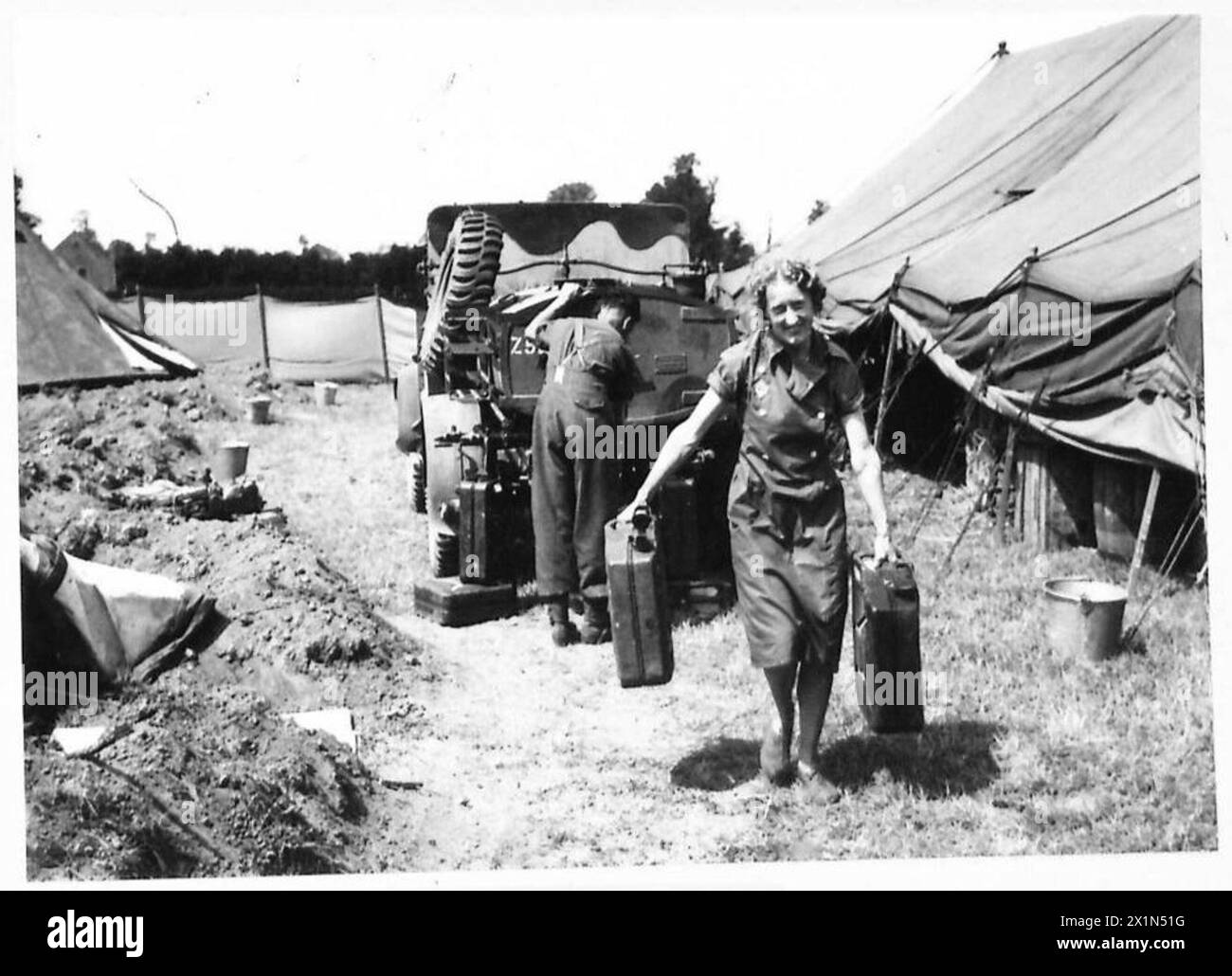 WOMENS' SERVICES IN NORMANDY - One of the major problems at a NAAFI in Normandy is water. An enormous amount is needed for tea. Here one of the ATS/AFI is seen carrying 4 gallon cans from water truck, British Army, 21st Army Group Stock Photo