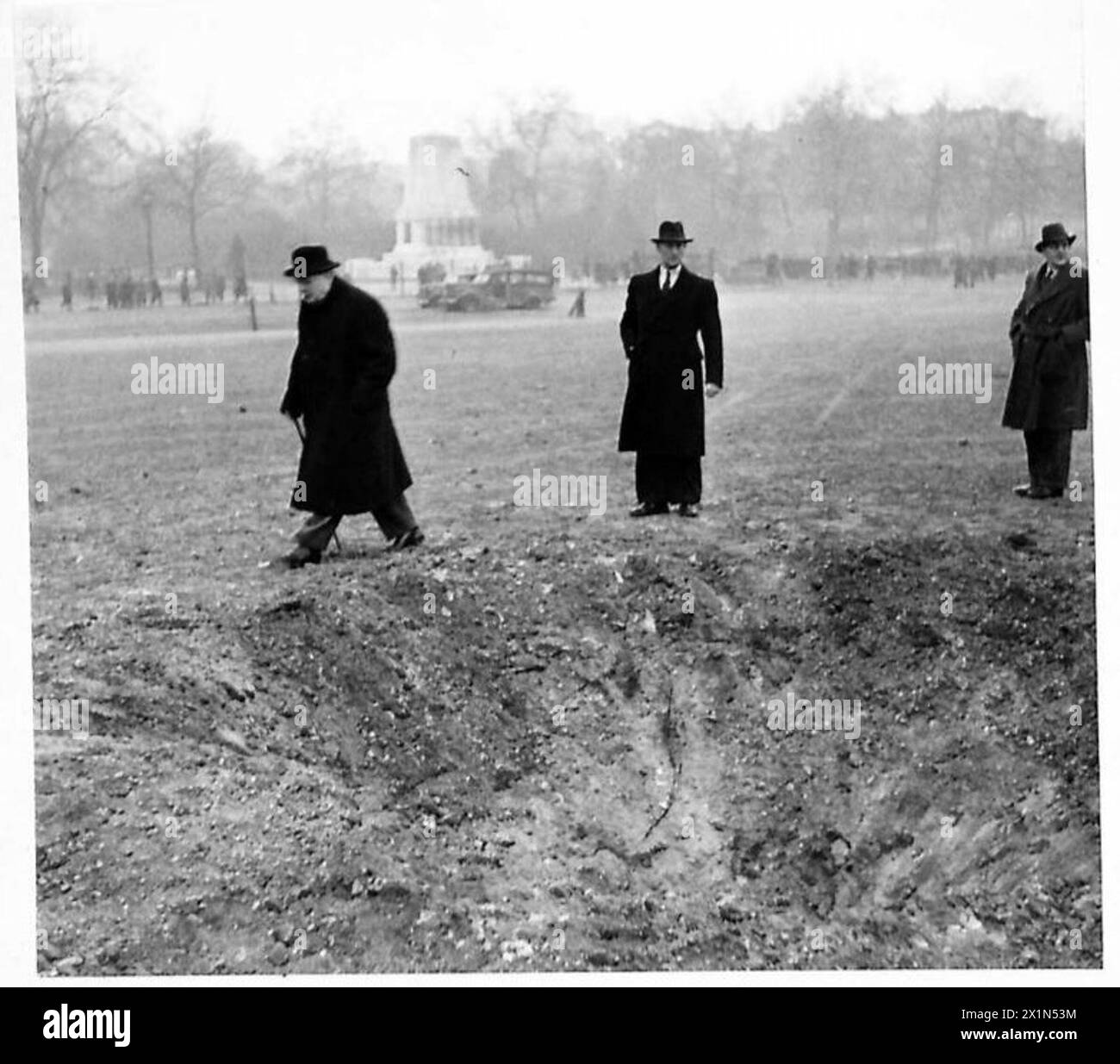 NO.10 DOWNING STREET DAMAGED DURING RAID - The Prime Minister walking past a bomb crater on Horse Guards Parade. Blast from this bomb caused most of the damage to No.10, British Army Stock Photo
