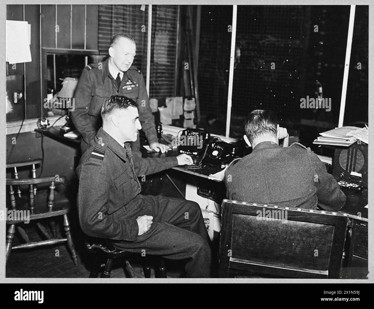IN COASTAL COMMAND 'OPS' ROOM - Picture (issued 1944) shows - Air Vice Marshal B.E. Baker, CB., DSO., MC., AFC., Air Officer Commanding a Coastal Command Group [centre] with Air Commodore N.H. D'Aeth, CBE., the Senior Air Staff Officer [extreme left], Royal Air Force Stock Photo