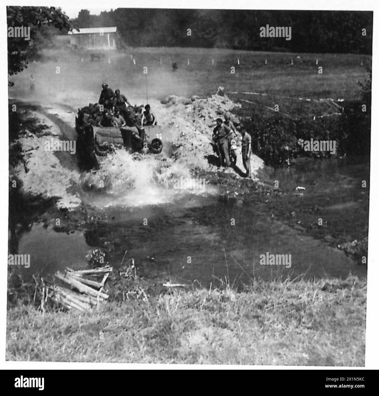 A British self-propelled gun crosses a stream while advancing in pursuit of enemy forces during operations by the 21st Army Group, British Army. Stock Photo