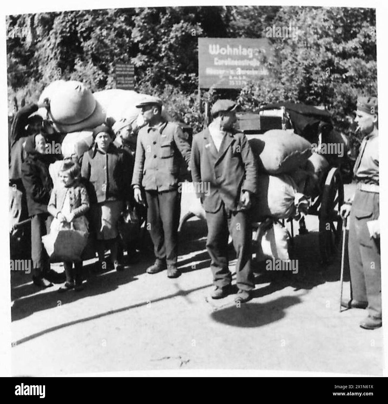 DISPLACED PERSONS AND REFUGEES IN GERMANY - Two Poles who are leaving the No.17 Displaced Persons Assembly Centre at Hamburg Zoological Gardens for a Polish national camp for repatriation, have so much luggage that they need a handcart to bring it to the lorry. The Displaced Persons camp within the grounds of Hamburg Zoo was build by the Blohm & Voss company during WWII to house the forced labourers that worked in their factory. The camp was taken over by the British on 5 May 1945 and quickly given over as an arrivals centre for displaced persons. On arrival displaced persons were organised in Stock Photo
