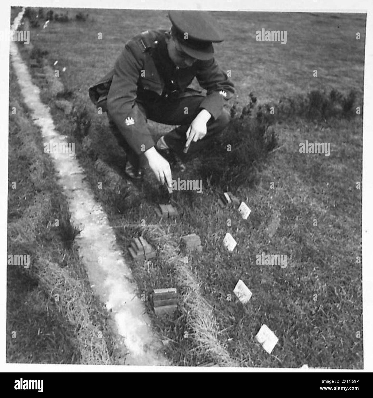 MINIATURE LAYOUT OF AMMUNITION RAILHEAD - A photograph comparing the size of ammunition against one of the depot personnel, British Army Stock Photo