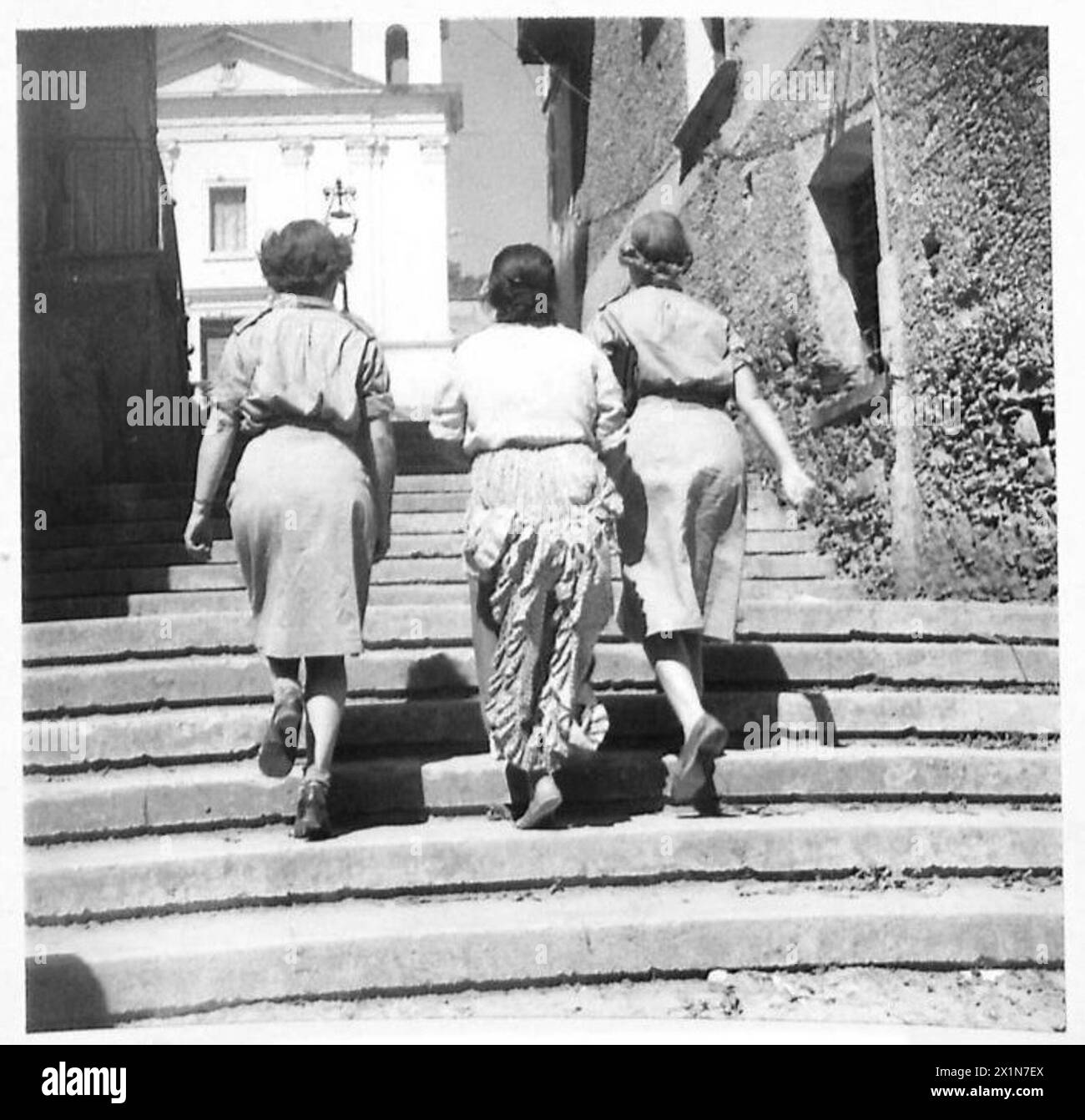 Two army Sisters, accompanied by a native woman, explore side streets ...