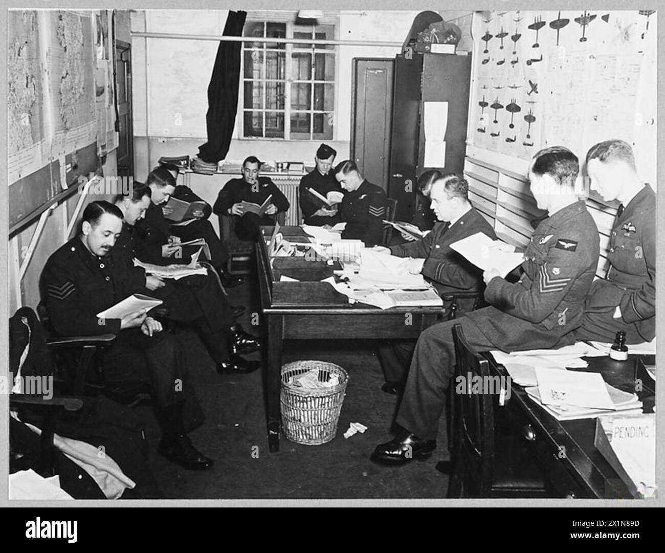 DEFEATING GERMANY'S KEY WEAPON : LIBERATOR v. U-BOAT - 9576 (Picture issued 1943) Members of Liberator air crews studying the shapes ans sizes of enemy ships and aircraft, and methods of attack and defence, during off-duty hours, Royal Air Force Stock Photo