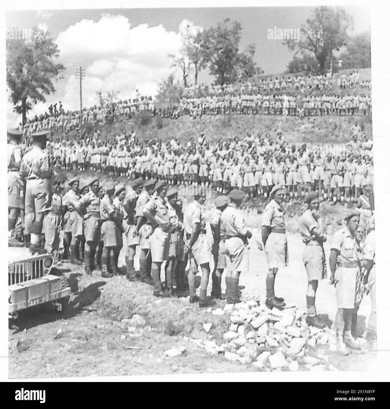 Troops of the British Eighth Army line the roadside outside Rosco, Italy, awaiting the visit of His Majesty the King during World War II. Stock Photo