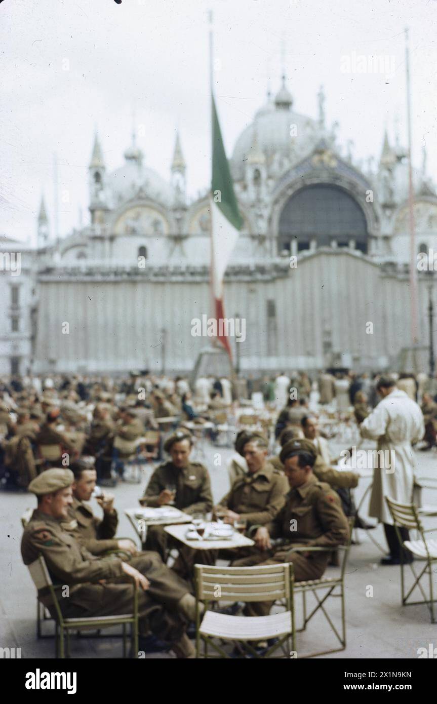 SOLDIERS OF THE BRITISH ARMY ON LEAVE IN VENICE, ITALY, JUNE 1945 - Corporal T Fenn, of Mottingham, London; Private E W Jones of Esher, Surrey; Private W J Leaman of Ashburton, nr Newton Abbot, Devon; Private A Clark of St Johns, Deptford, London; and Private G C Foreman of Warminster, Wiltshire, at an open air cafe in the Piazza San Marco. The famous church is in the background, British Army Stock Photo