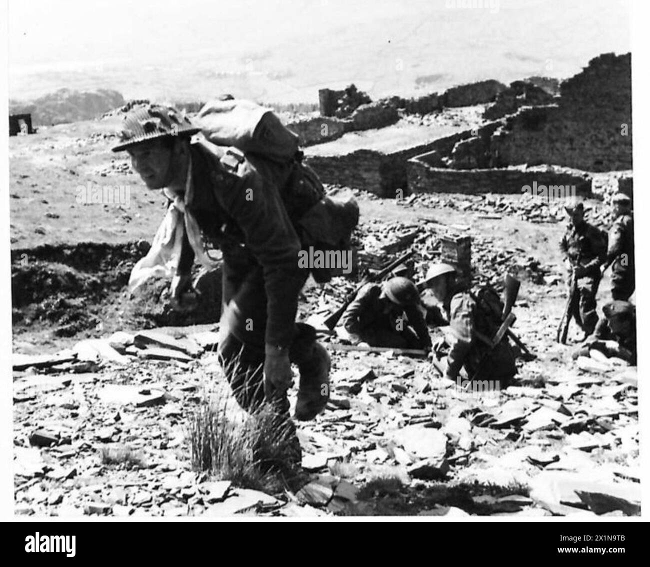 TOUGHENING-UP AT A BATTLE SCHOOL - A captain leads his men through the quarry to make the final attack, British Army Stock Photo