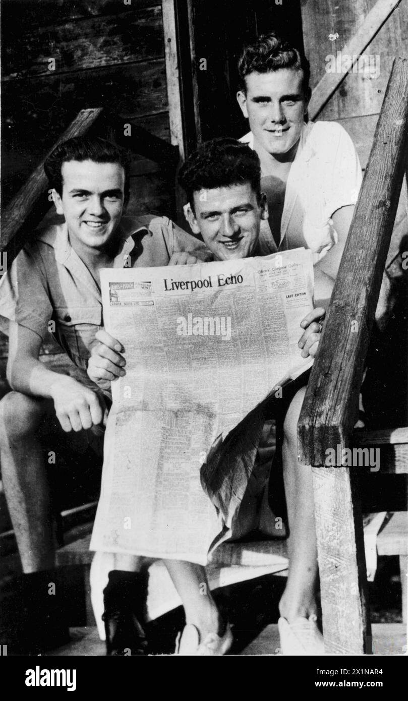NEWS FROM HOME. 9 JUNE 1944, PIARCO, TRINIDAD, AT A ROYAL NAVAL AIR STATION. FLEET AIR ARM MEN KEEP ABREAST OF THE HOME NEWS DURING AN OFF DUTY SPELL. - Left to right: A Leeks, of Liverpool; P Smith of Old Swan, Liverpool: and V Connor, of Liverpool 5, reading the home news in their local paper, Stock Photo
