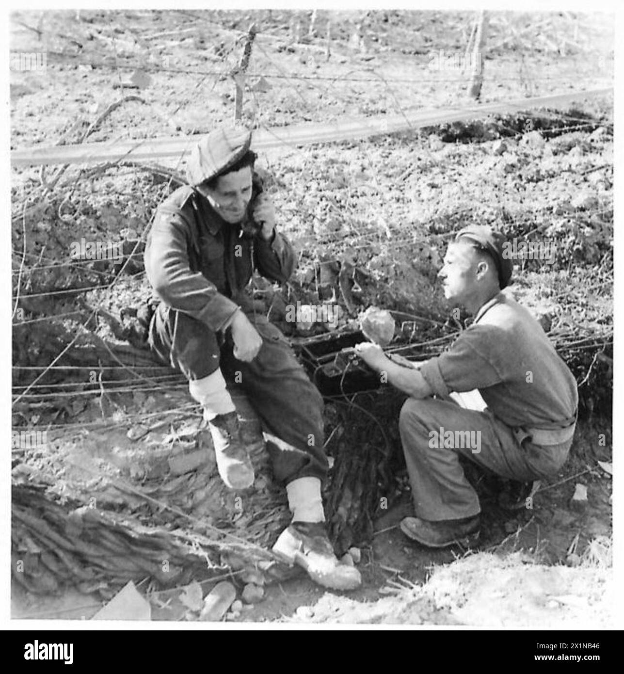 Wireless operators of an Anti-Tank Regiment, Royal Artillery, search for a gap in the lines. Personnel include Gnr. William Collin and Gnr. Edward Hall, with service histories in North Africa, Sicily, and Italy, previously employed in civilian occupations, now serving in the British Army. Stock Photo
