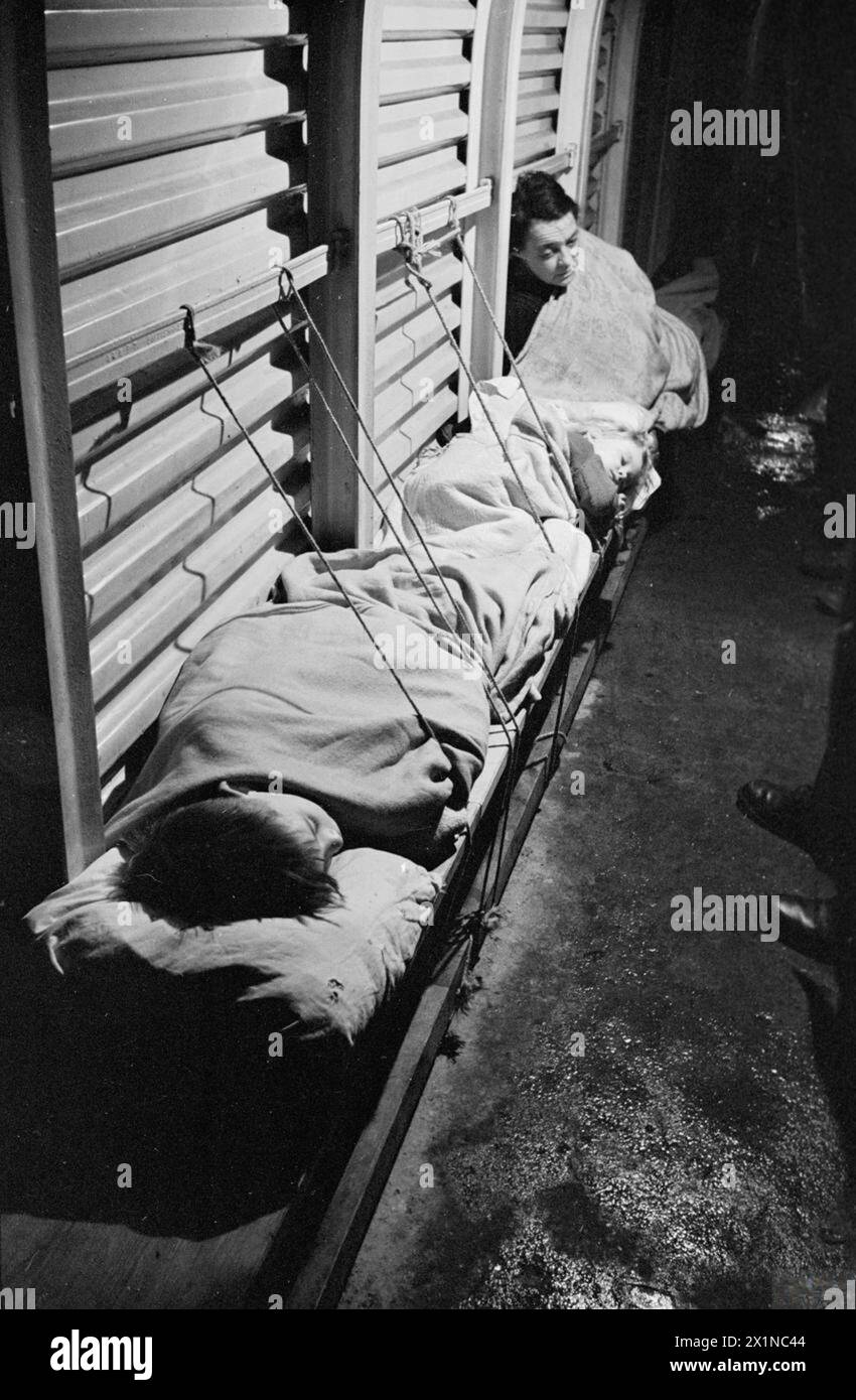 Sleep On Rope Two children sleep on a bench in a flooded trench shelter in London ...
