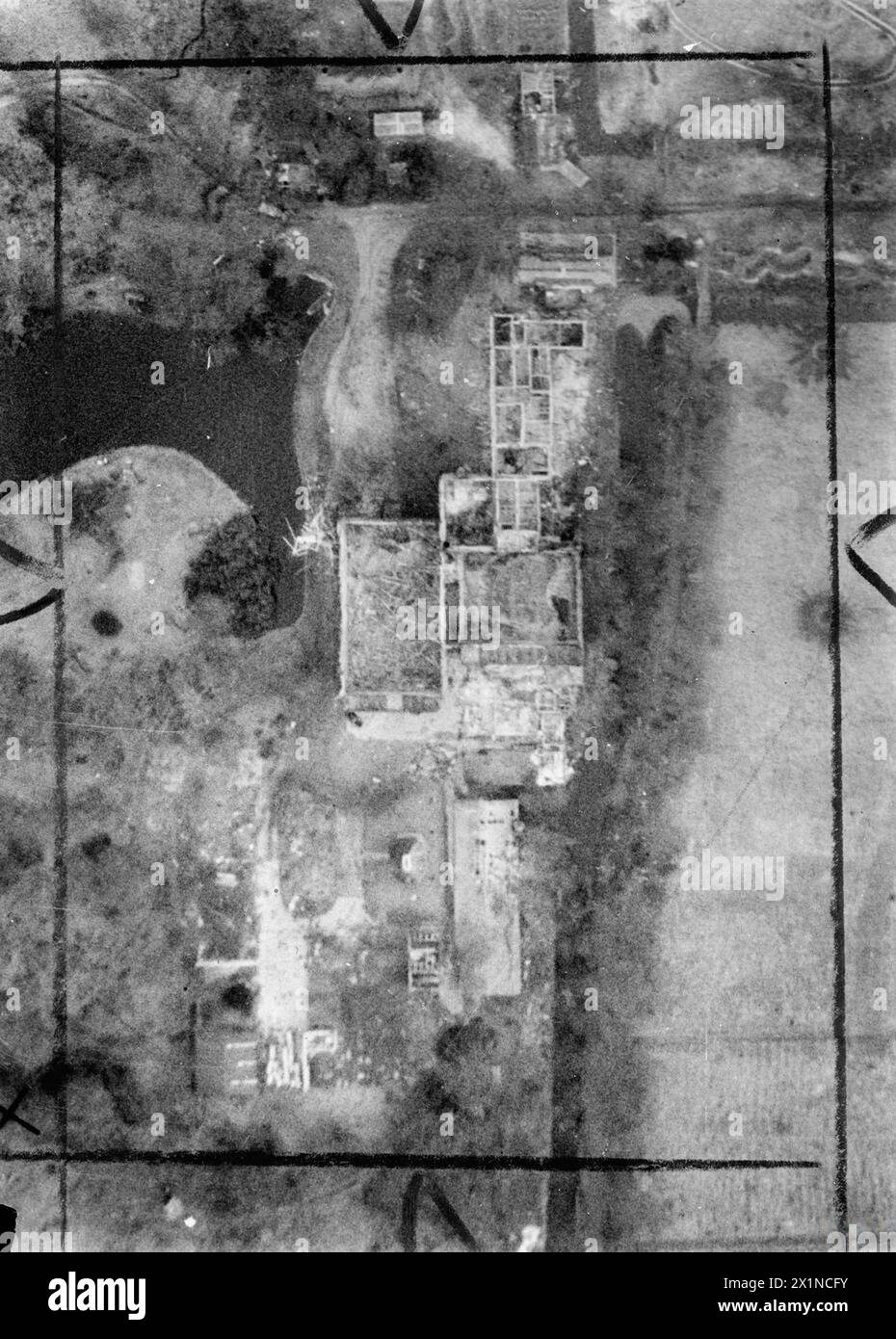 ROYAL AIR FORCE: OPERATIONS BY THE PHOTOGRAPHIC RECONNAISSANCE UNITS, 1939-1945. - Part of a vertical photographic-reconnaissance aerial, showing buildings of former film studios in Haagsche Bosch, Holland, which were being used to fire V2 rockets, following their destruction by Supermarine Spitfire fighter-bombers of Fighter Command, Royal Air Force, 106 Group Stock Photo