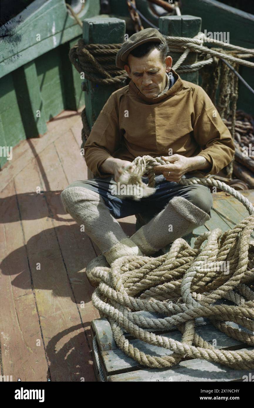 Mr De Groote A Belgian Fisherman Is Shown Splicing Rope On The Deck mr-de-groote-a-belgian-fisherman-is-shown-splicing-rope-on-the-deck
