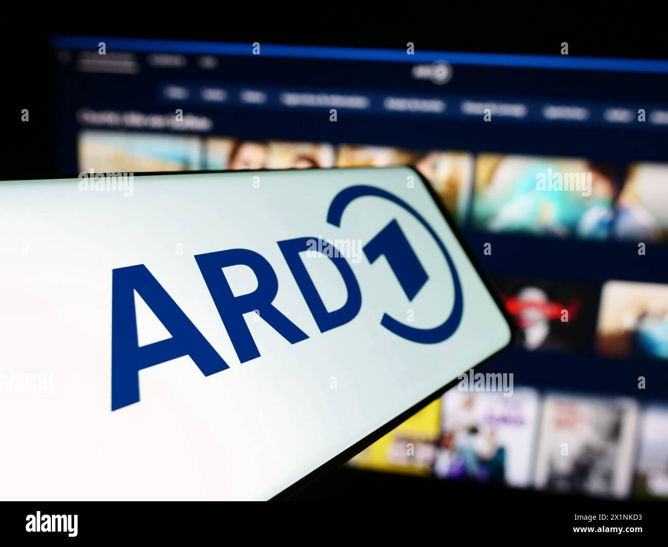 Smartphone with logo of German public-service broadcasting organisation ARD in front of website. Focus on center-left of phone display. Stock Photo