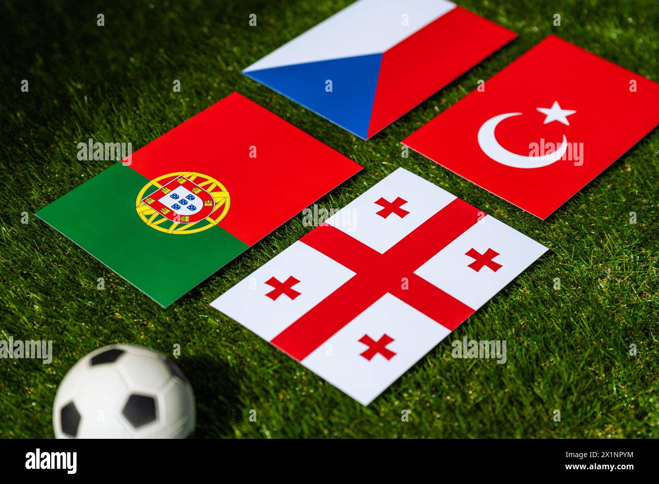 Football Tournament in Germany 2024: Group F and national flags of Turkey, Georgia, Portugal, Czech Republic and soccer ball on green grass Stock Photo