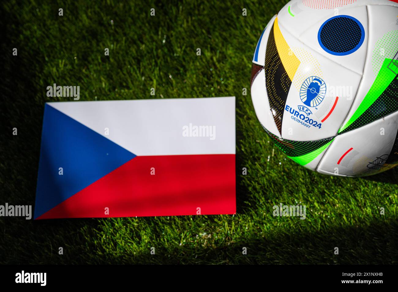 BERLIN, GERMANY, APRIL 17, 2024: Czech Republic national flag and official soccer ball of Euro 2024 football tournament in Germany placed on green gra Stock Photo