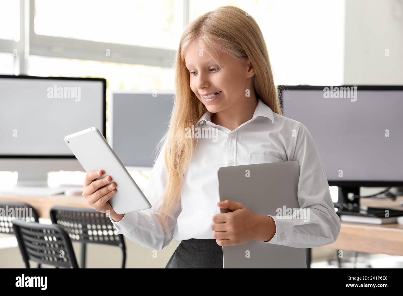 Little girl with modern devices at school computer lab Stock Photo - Alamy