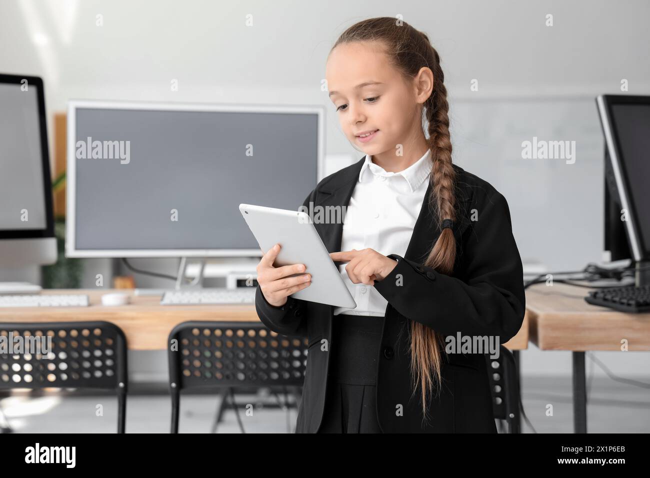 Little girl studying with tablet at school computer lab Stock Photo - Alamy