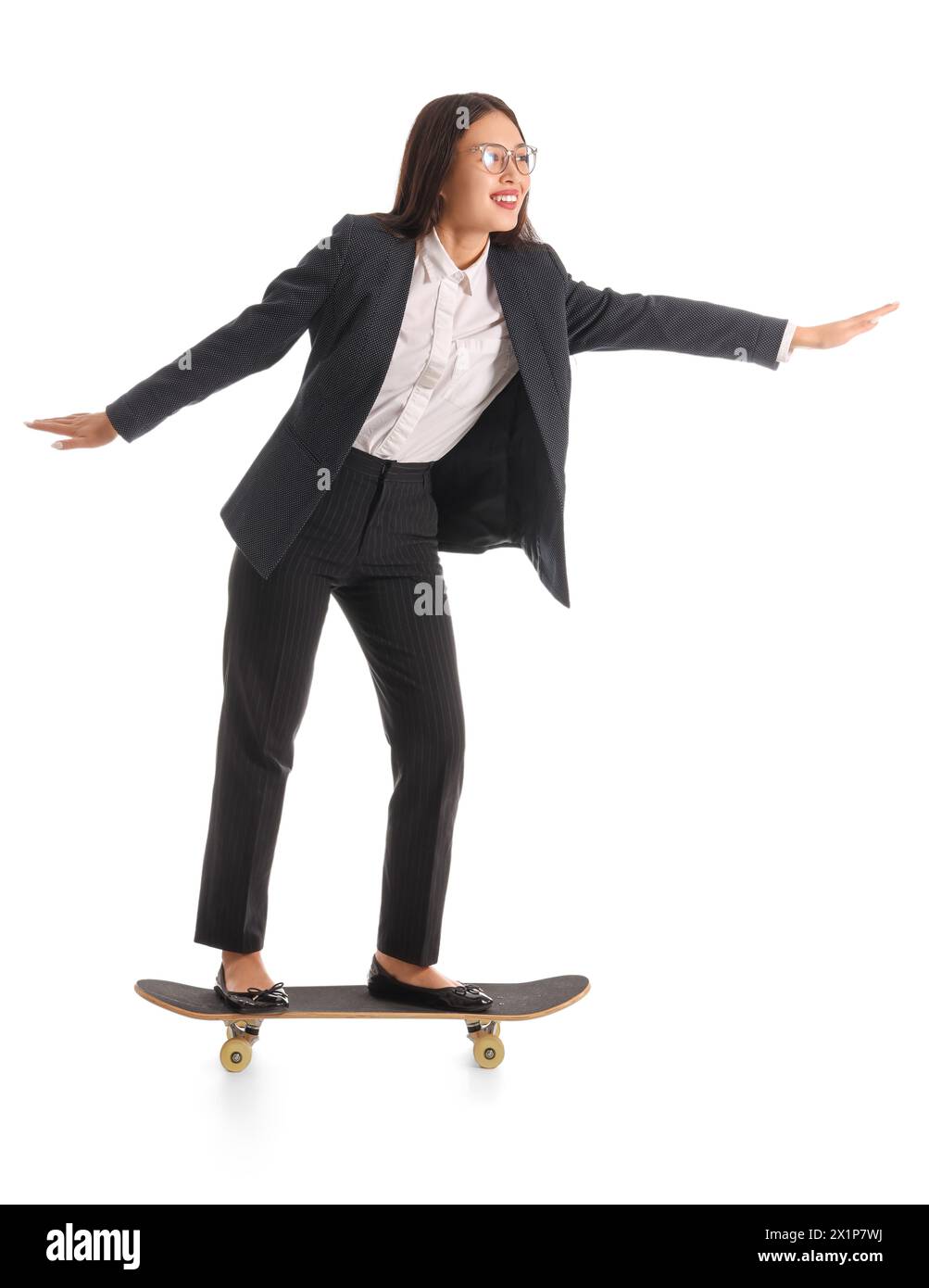 Funny Asian businesswoman riding skateboard on white background Stock Photo
