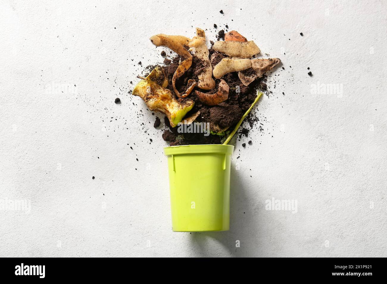 Bin with organic waste and soil on white grunge background. Compost recycling concept Stock Photo