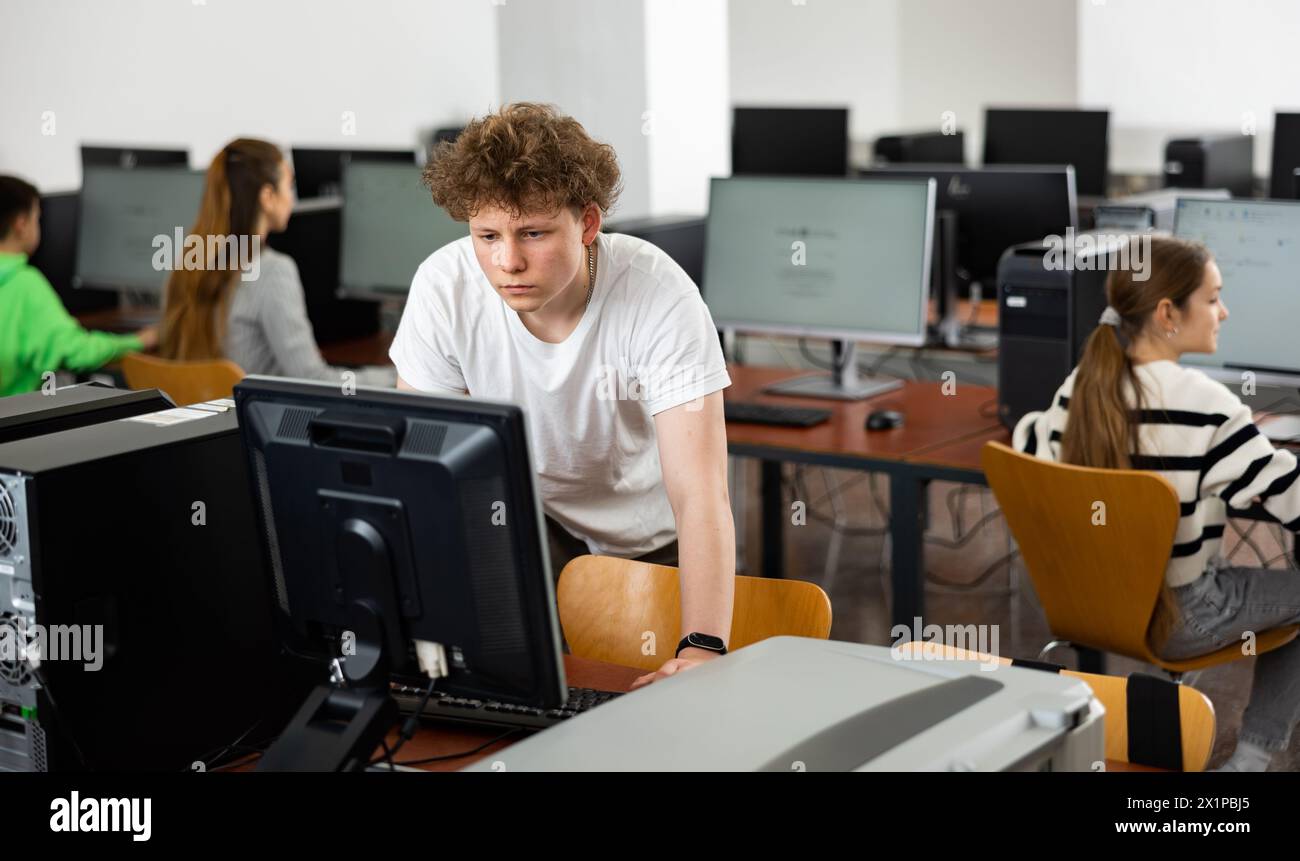 Teenage boy learning to use personal computer during lesson Stock Photo ...
