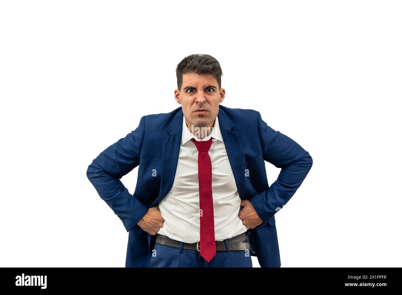 intense fury of a businessman as he glares furiously at the camera, with hands on hips displaying an attitude of anger and frustration.he embodies cor Stock Photo