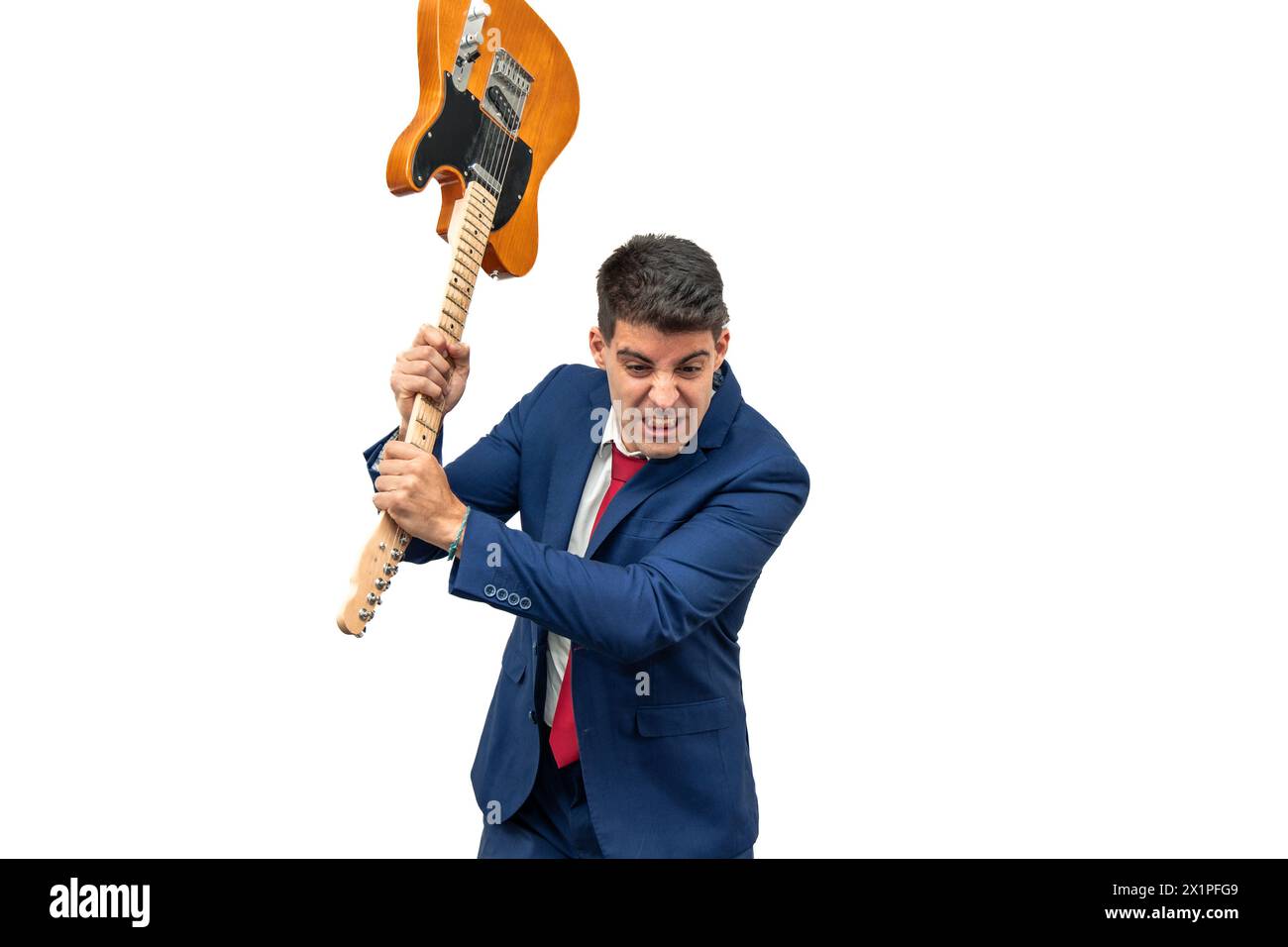 furious expression of a businessman as he smashes an electric guitar against the ground in a fit of rage. embodies corporate aggression and violence w Stock Photo
