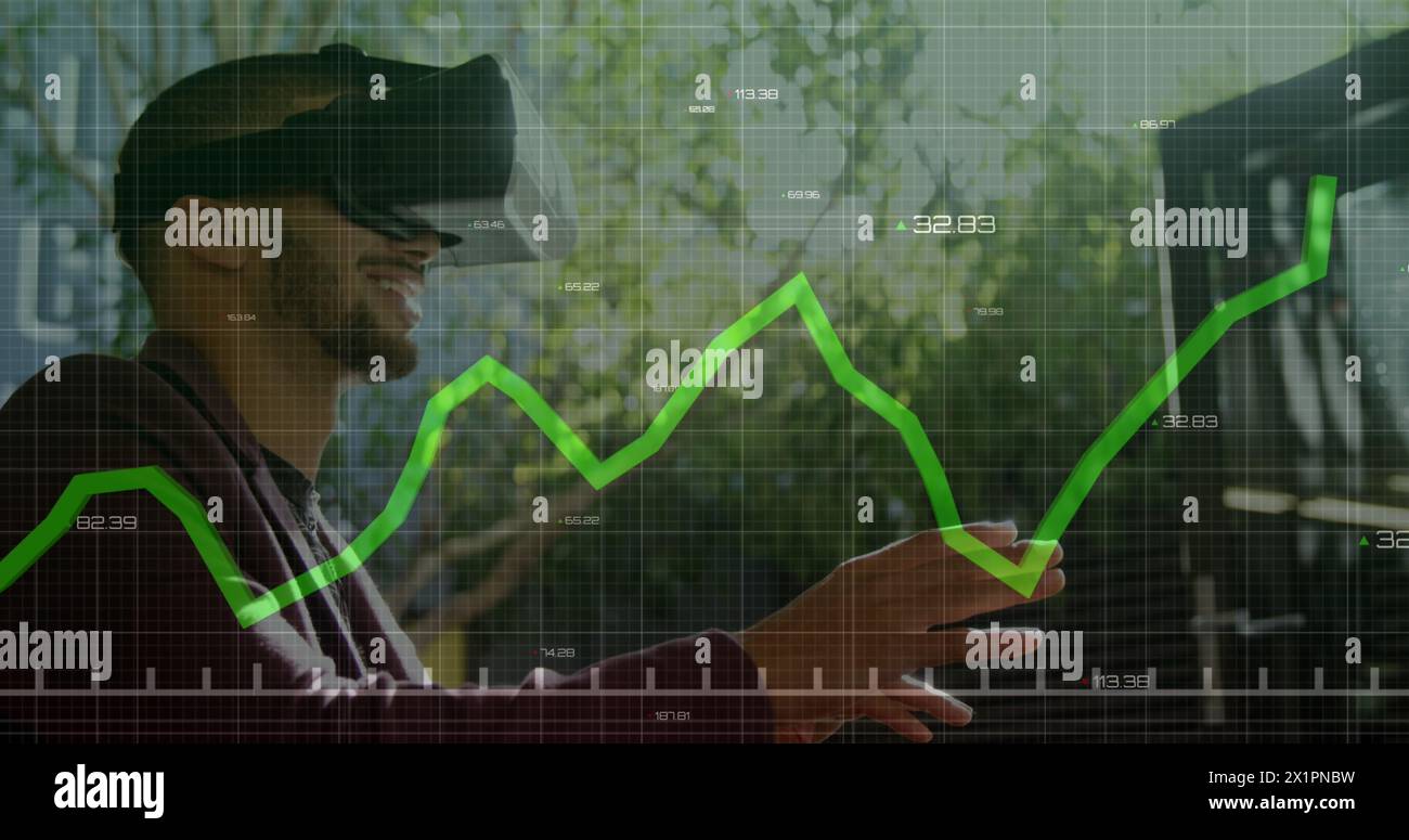Biracial young man wearing VR headset, analyzing data Stock Photo