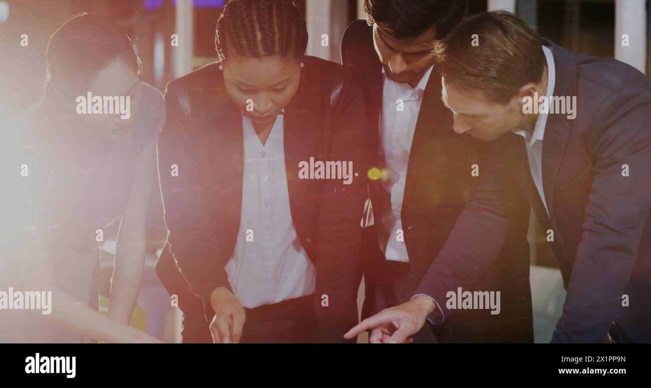 Diverse group of colleagues examining documents on table Stock Photo