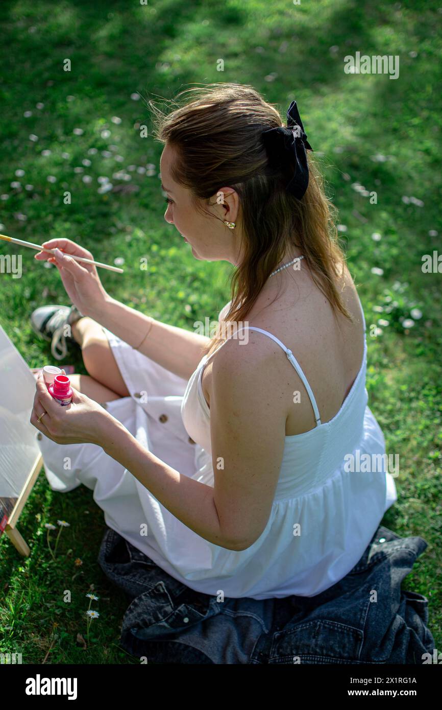 Female artist paints a picture with pink paints. Stock Photo