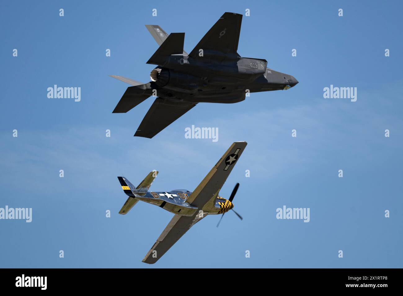 A P-51 Mustang flies in formation with Capt. Melanie “MACH” Kluesner, F-35A Lightning II Demonstration Team pilot and commander, during the SUN ‘n FUN Stock Photo
