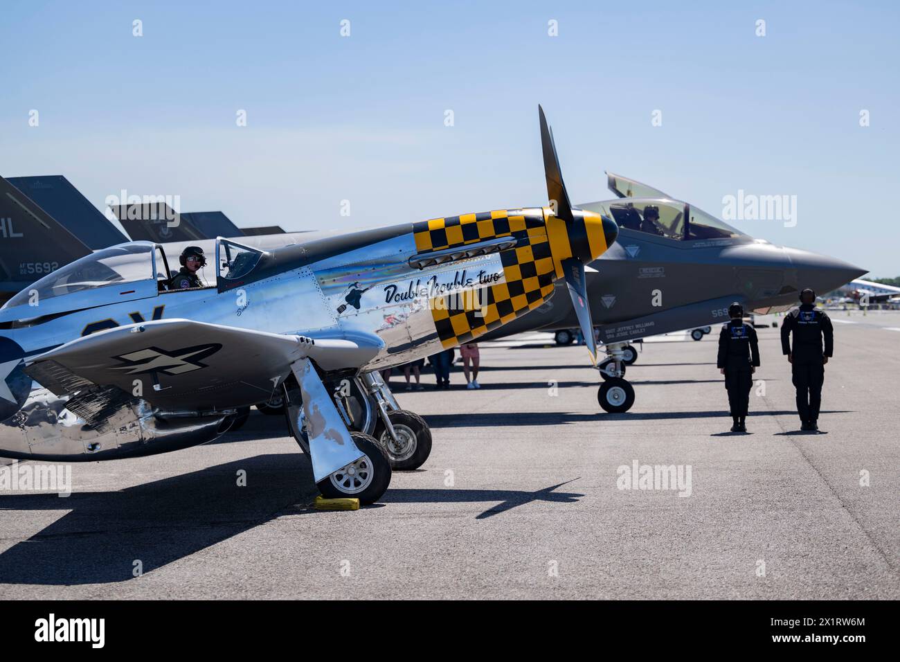 A P-51 Mustang sits in formation with Capt. Melanie “MACH” Kluesner, F-35A Lightning II Demonstration Team pilot and commander, during the SUN ‘n FUN Stock Photo