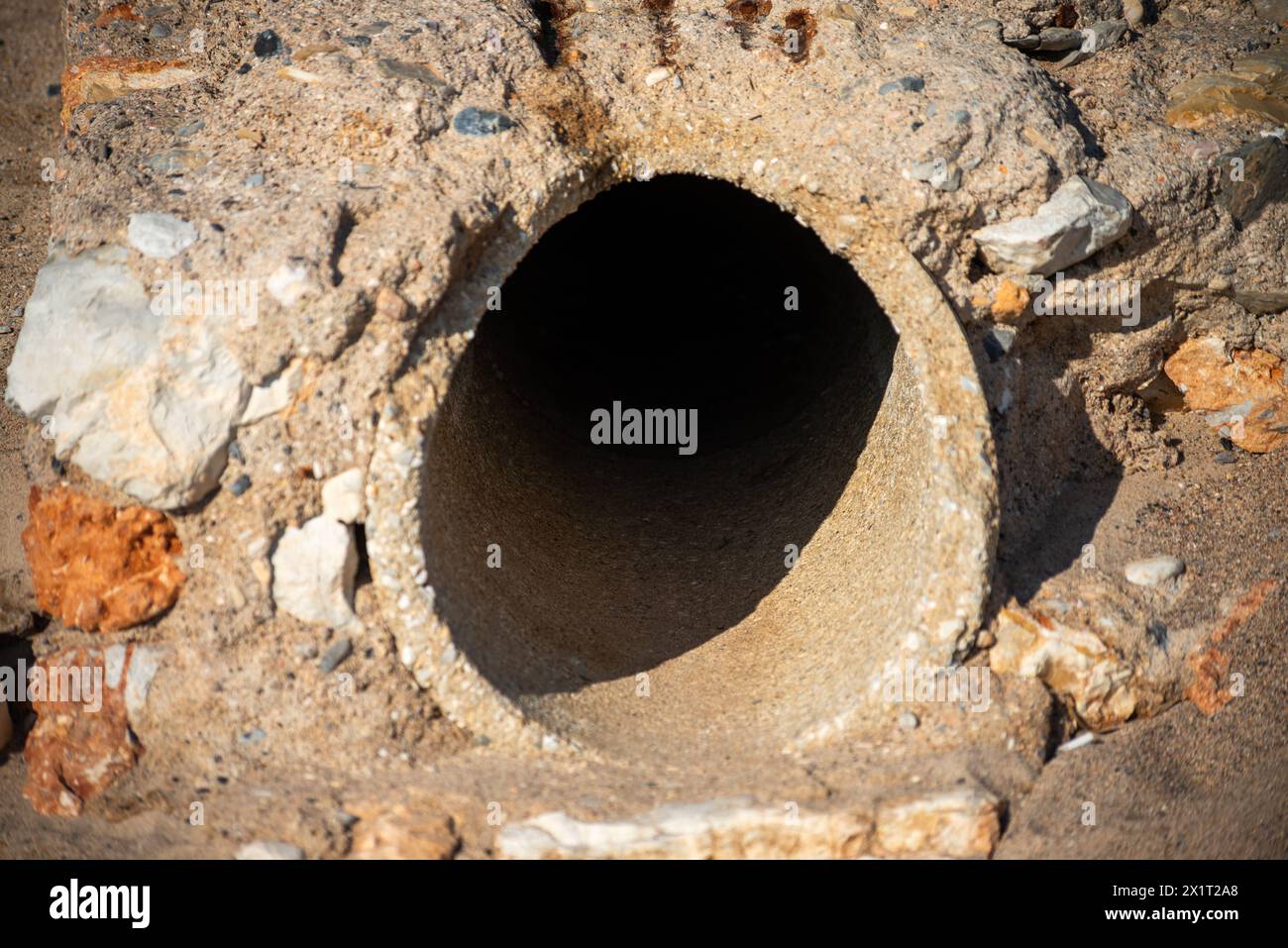 Discover the hidden infrastructure beneath the sands—a big concrete pipe silently serving its purpose underground. Stock Photo