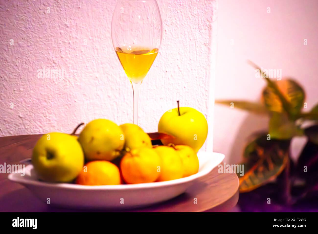 Savor the delightful combination of mandarins, green apples, and a glass of wine for a refreshing and flavorful indulgence. Stock Photo