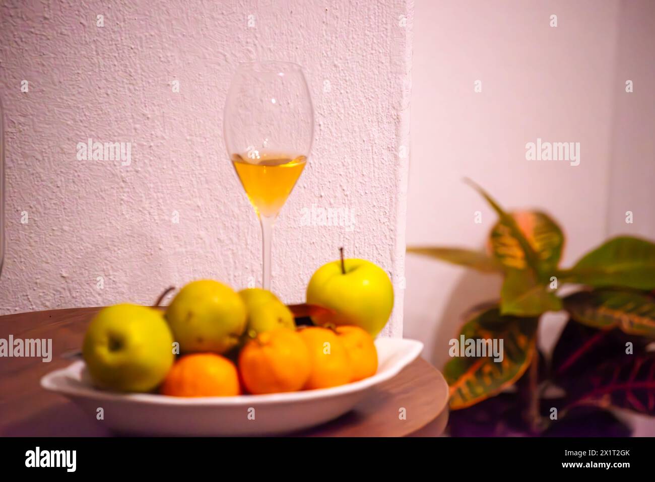 Savor the delightful combination of mandarins, green apples, and a glass of wine for a refreshing and flavorful indulgence. Stock Photo