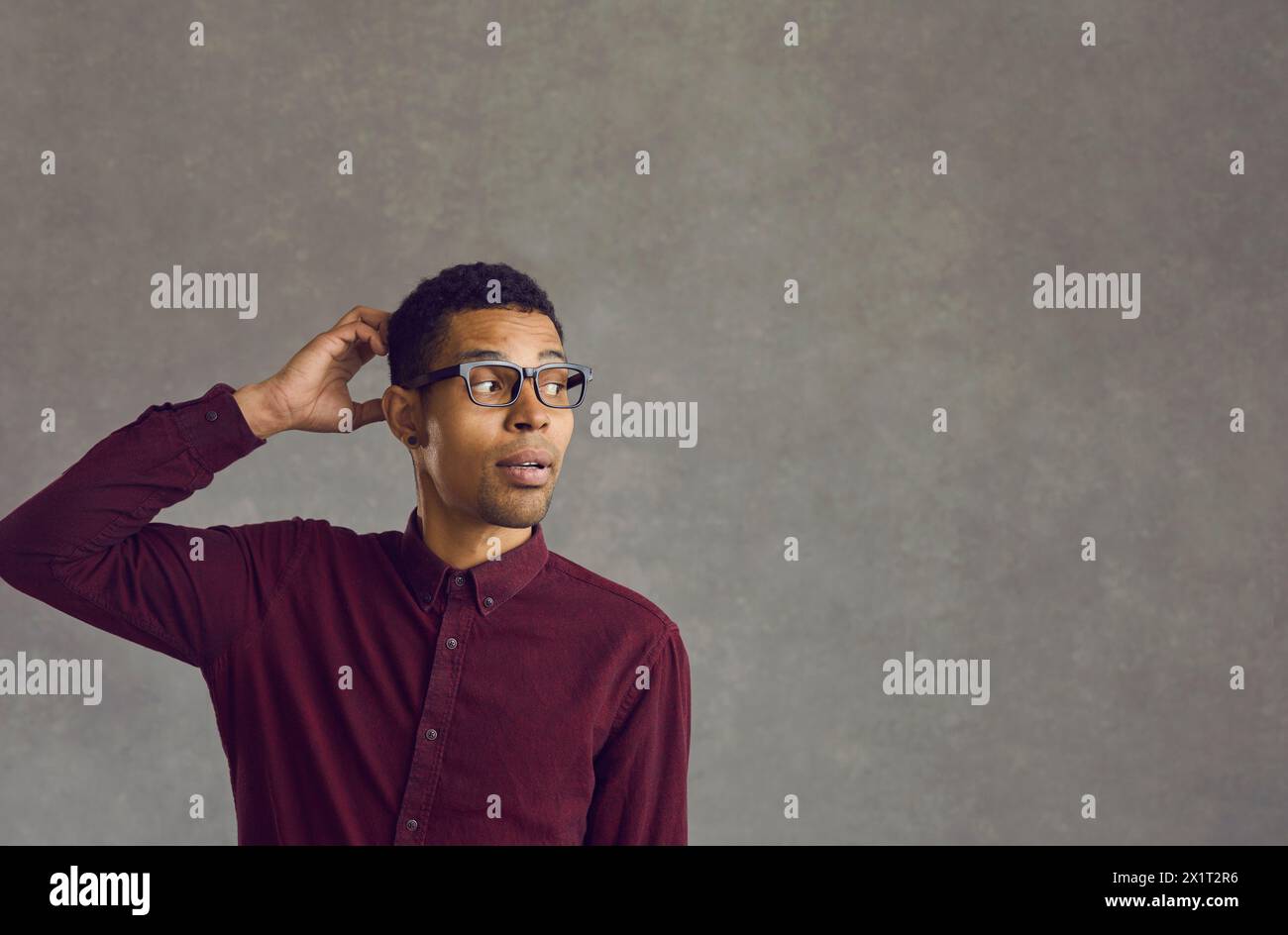 Questioning african american man scratching head standing over grey copy space Stock Photo