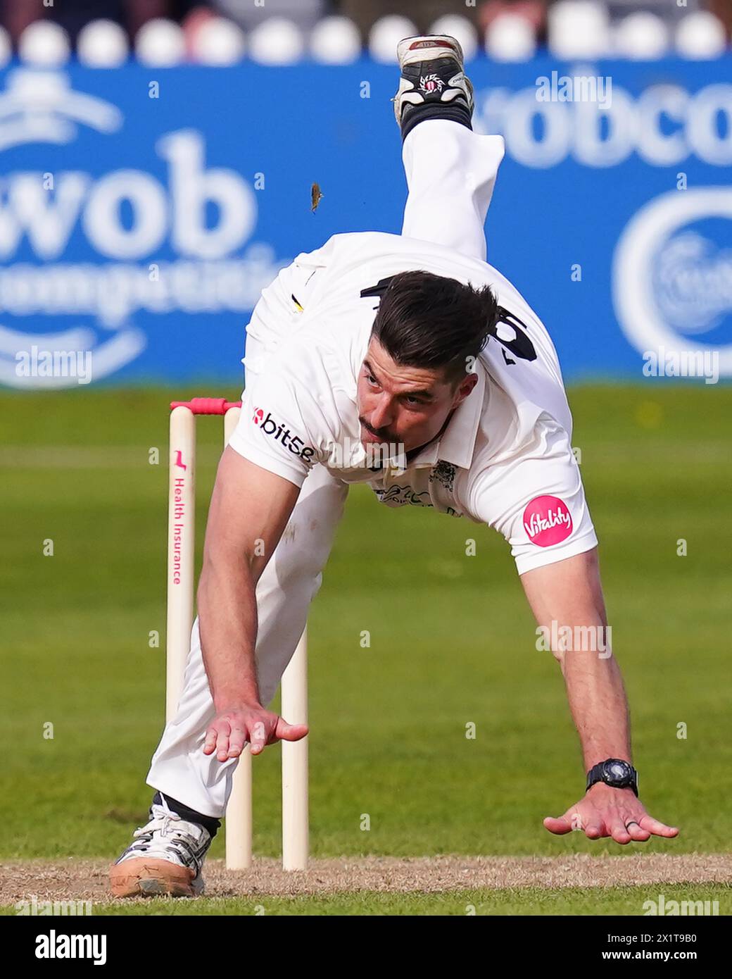 Bristol, UK, 14 April 2024. Gloucestershire's Marchant de Lange falls over while he bowls during the Vitality County Championship match Stock Photo