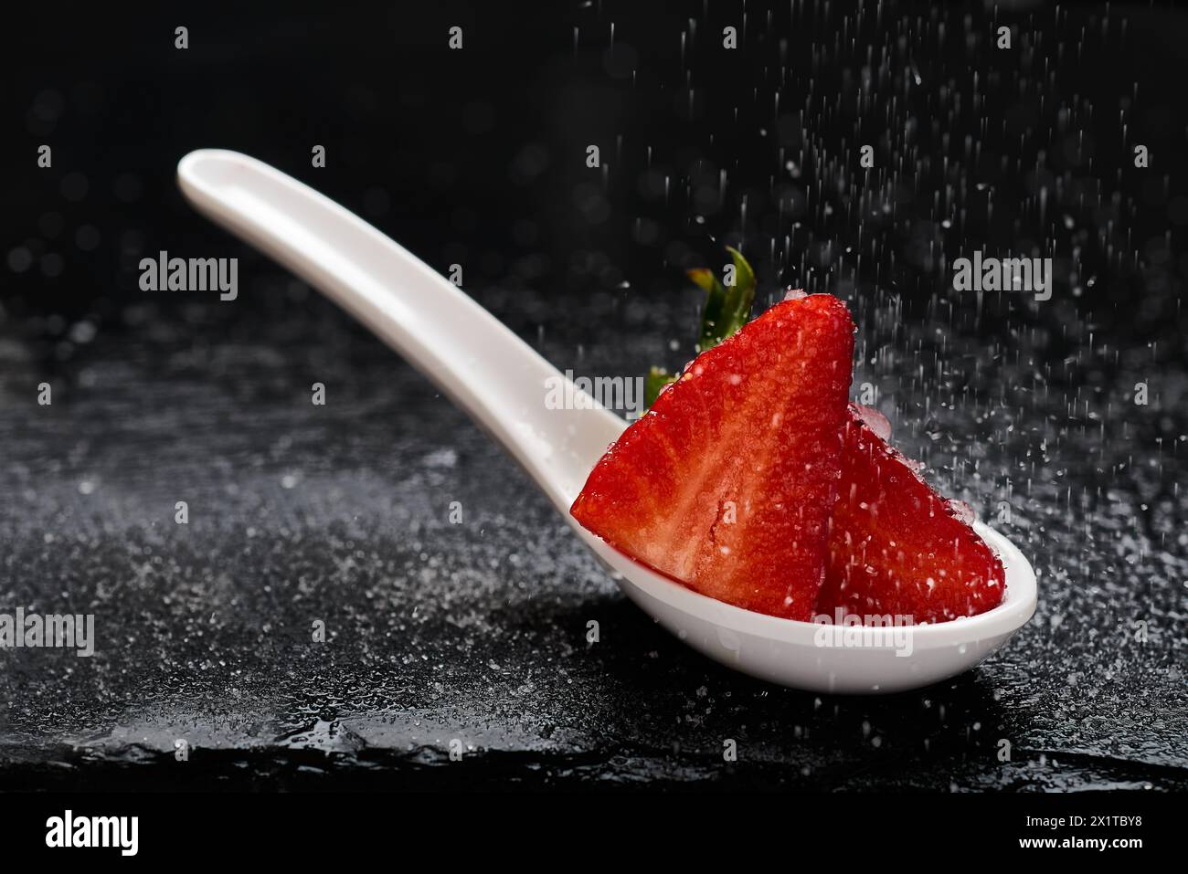 Strawberries over white spoon and Sugar falling Stock Photo - Alamy