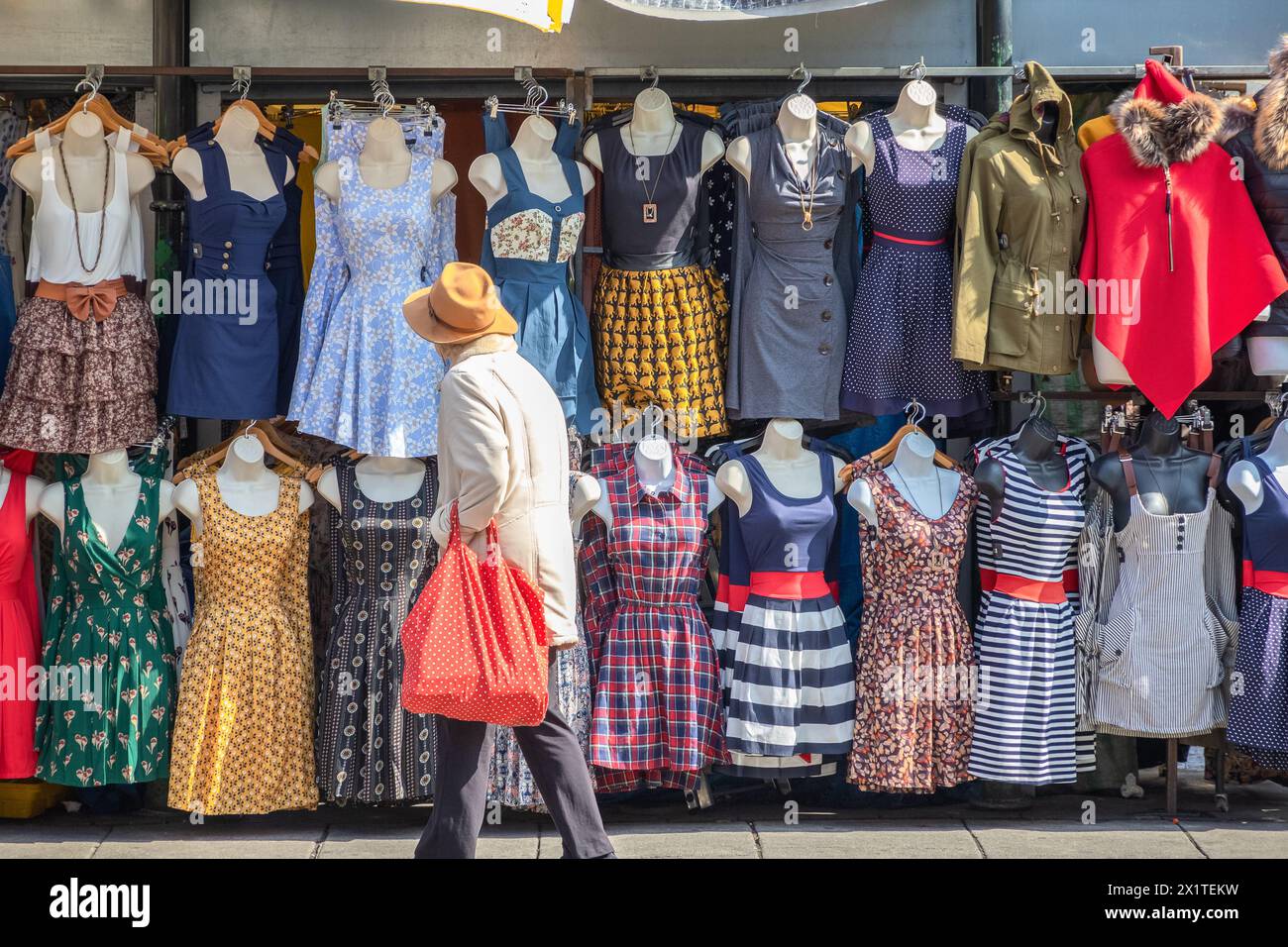 London, UK - 12 September, 2018 - A tourist browsing a range of sundresses on display at Camden market Stock Photo